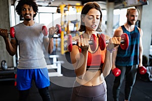 Group of young people doing exercises in gym