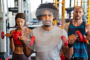 Group of young people doing exercises in gym