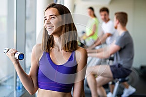 Group of young people doing exercises in gym to stay healthy. Sport gym workout friends concept.