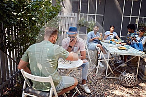 Group of young people enjoy in cafe`s garden
