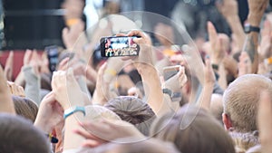 Group Of Young People Enjoying Outdoor Music Festival. Close-up rear view of crowd on concert. Funny people shoot a