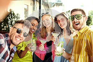 Group of young people, friends taking selfie together, meeting at cafe, drinking cocktails, talking, celebrating. Joyful