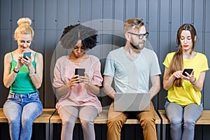 Group of young people with gadgets indoors