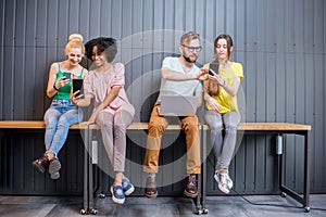 Group of young people with gadgets indoors