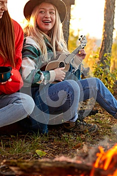 Group of young people have rest near bonfire in the nature