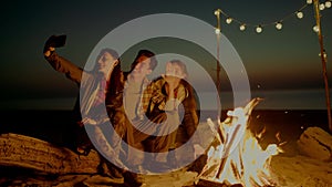 Group of young people having camp on the beach at night