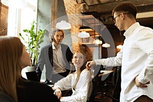 Group of young people having discussion before lesson. Computer science with professional IT tutor.