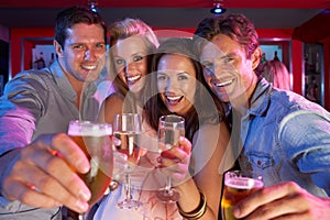 Group Of Young People Having Fun In Busy Bar