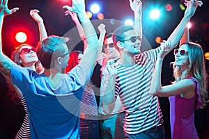 Group of young people having fun dancing at party