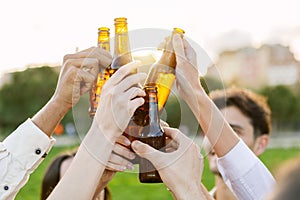 Group of young people having fun drinking beer at summer party outdoors