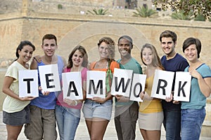 Group of young people holding teamwork sign