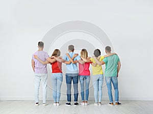 Group of young people hugging each other near wall. Unity concept