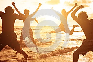 Group of young people jumping at the beach