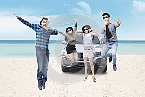 Group of young people jumping on beach