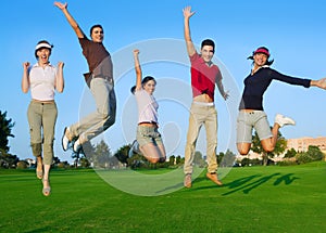 Group of young people jumping outdoors grass
