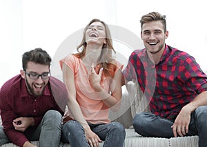 Group of young people laughing and sitting on the couch