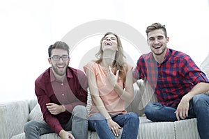 Group of young people laughing and sitting on the couch