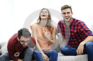 Group of young people laughing and sitting on the couch