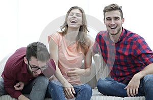 Group of young people laughing and sitting on the couch