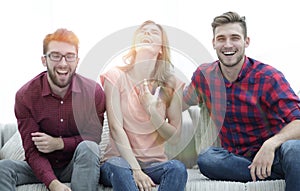 Group of young people laughing and sitting on the couch