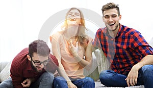 Group of young people laughing and sitting on the couch