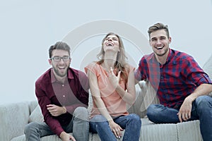 Group of young people laughing and sitting on the couch