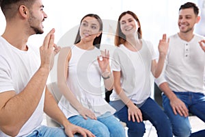 Group of young people learning sign language with teacher