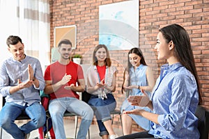 Group of young people learning sign language with teacher