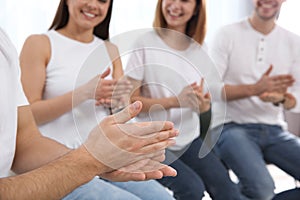 Group of young people learning sign language with teacher indoors