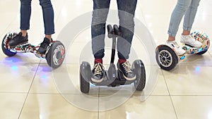 Group of young people are moving around the shopping center on a hyroscooter. photo