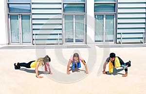 Group of young people performing pushups in modern urban area