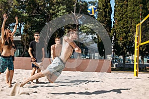 Group of young people playing volleyball on the beach