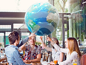 Group of young people pointing at planet Earth