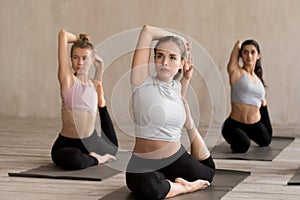 Group of young people practicing yoga lesson doing Mermaid exerc
