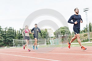 Group of young people running on the track field