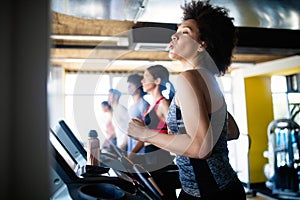 Group of young people running on treadmill in gym