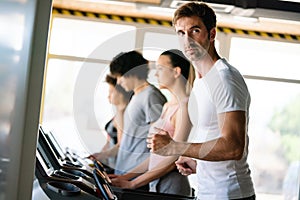 Group of young people running on treadmill in gym