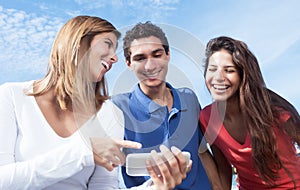 Group of young people showing pictures at phone