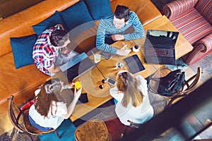 Group of young people sitting at a cafe, talking and enjoying