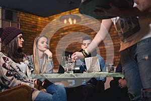 Group of young people sitting in a coffee shop having fun