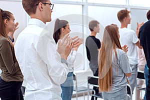 group of young people standing applauding in the conference room .