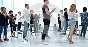 group of young people standing applauding in the conference room.