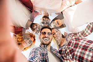 Group of young people standing in a circle, making a selfie