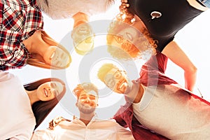 Group of young people standing in a circle, outdoors