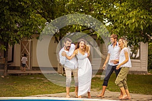 Group of young people by the swimming pool