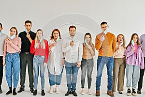 group of young people taking off protective medical face mask during coronavirus and flu outbreak