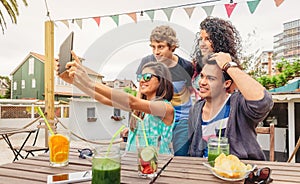 Group of young people taking a selfie with tablet