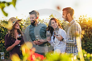 Group of young people tasting wine in winery near vineyard