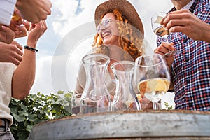 Group of young people tasting wine in winery near vineyard