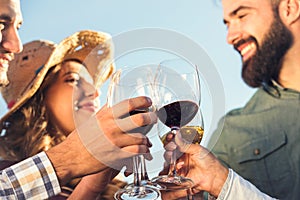 Group of young people tasting wine in winery near vineyard